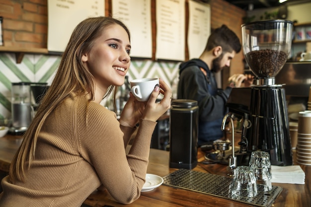 Jeune femme blonde au comptoir du bar