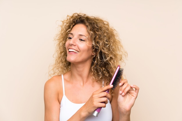 Jeune femme blonde aux cheveux bouclés avec un peigne