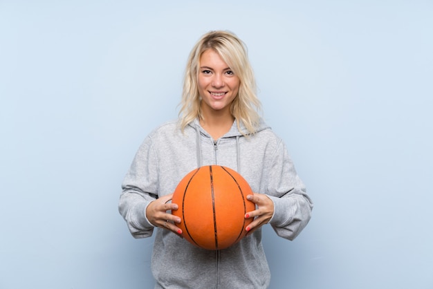 Jeune femme blonde avec une balle de basket