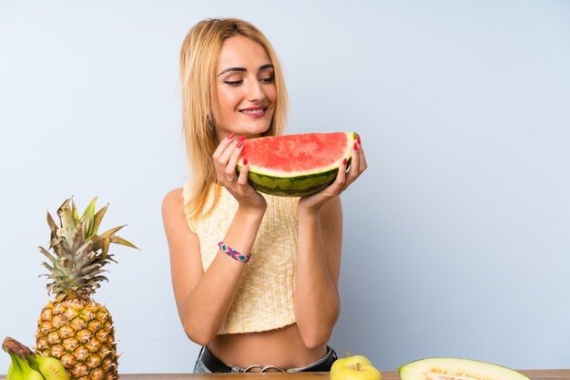 Jeune femme blonde avec beaucoup de fruits