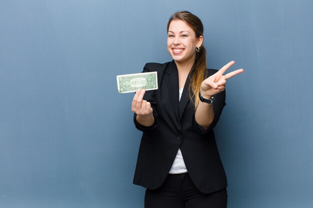 Jeune femme blonde avec des billets en dollars sur fond de mur de grunge