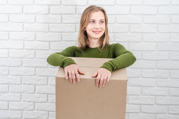 Jeune femme blonde avec boîte à colis Livrer un colis