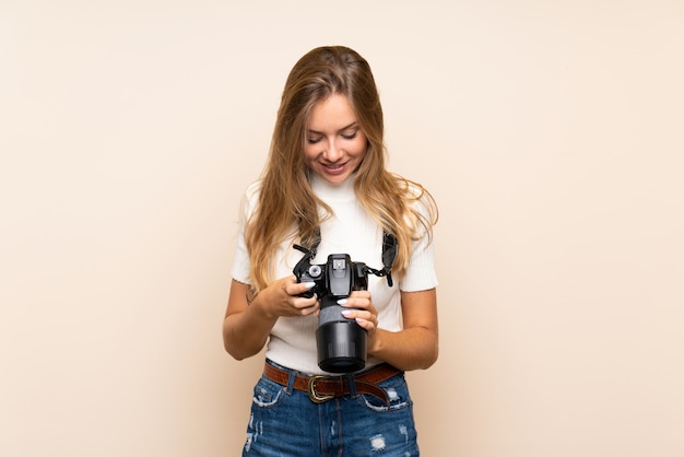 Jeune femme blonde avec une caméra professionnelle