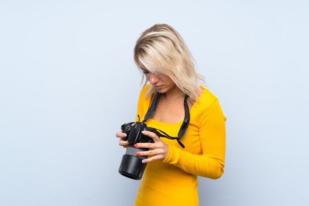 Jeune femme blonde avec une caméra professionnelle