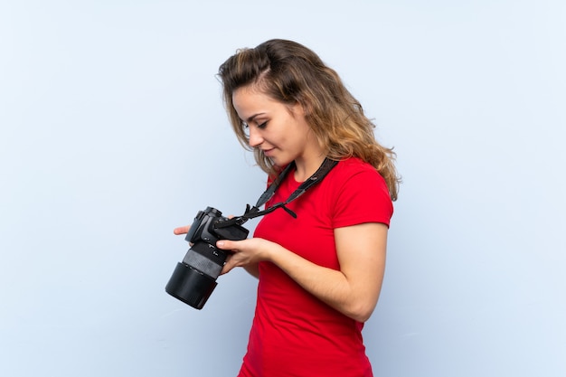 Jeune femme blonde avec une caméra professionnelle