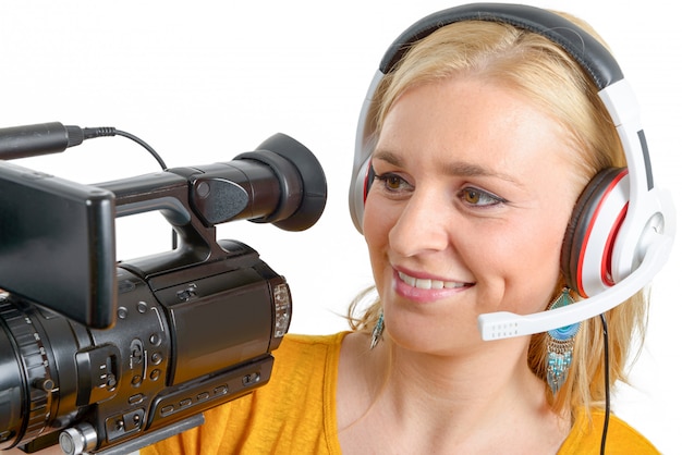 Jeune femme blonde avec caméra vidéo professionnelle, blanc