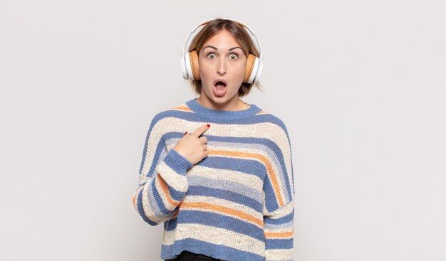 Jeune femme blonde à la choqué et surpris avec la bouche grande ouverte, pointant vers soi