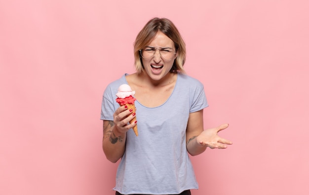 Jeune femme blonde à la colère, agacé et frustré crier wtf