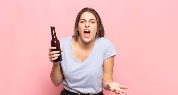 Jeune femme blonde à la colère, agacé et frustré de crier