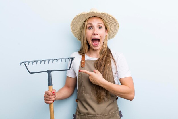 Jeune femme blonde avec un concept de fermier de râteau