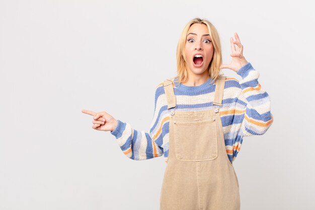 Jeune femme blonde criant avec les mains en l'air