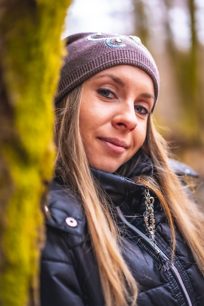 une jeune femme blonde dans une forêt en automne