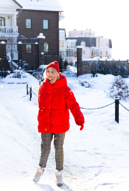 Jeune femme blonde élégante dans la rue s'amuse à poser dans la neige givrée