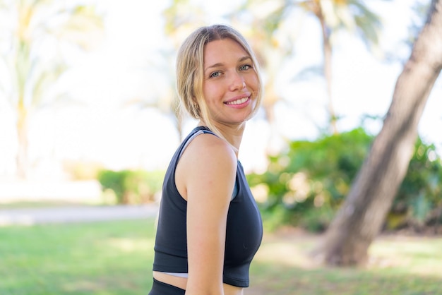 Jeune femme blonde à l'extérieur avec une expression heureuse