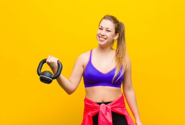 Jeune femme blonde avec un haltère. concept sportif