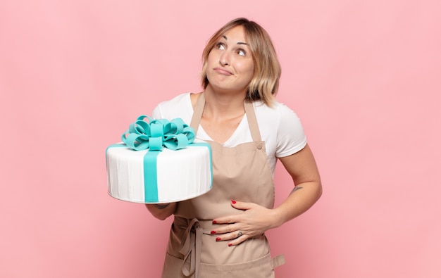 Jeune femme blonde haussant les épaules, se sentant confus et incertain, doutant des bras croisés et regard perplexe