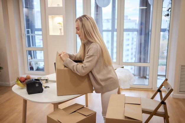 Jeune femme blonde imprimante code-barres et boîtes sur le fond pour les places de marché