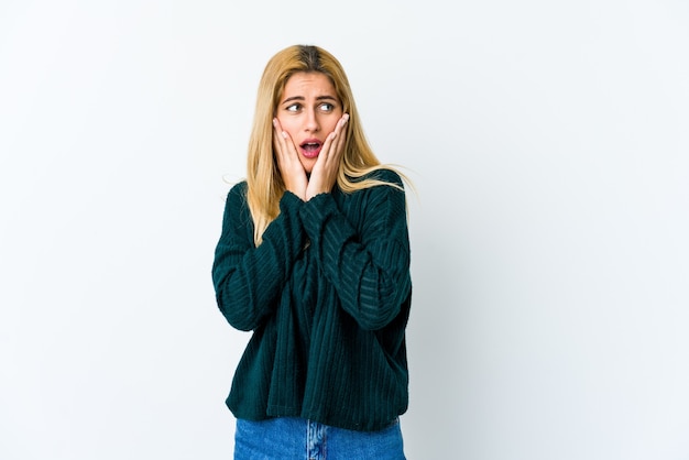 Jeune femme blonde isolée sur blanc peur et peur.