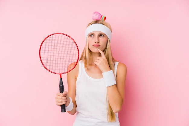 Jeune femme blonde jouant au badminton isolé