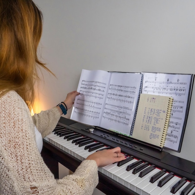 Photo jeune femme blonde jouant avec le piano et touchant la partition