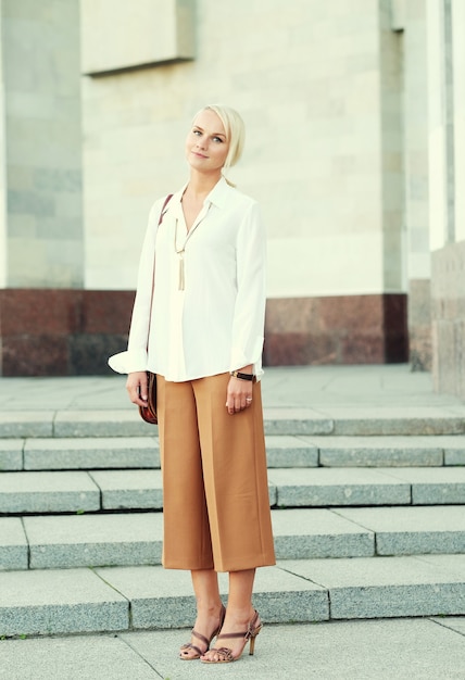 Jeune femme blonde marchant dans la rue