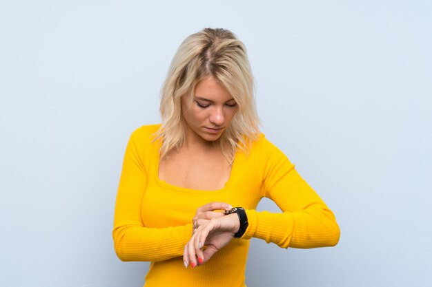 Jeune femme blonde avec une montre au poignet