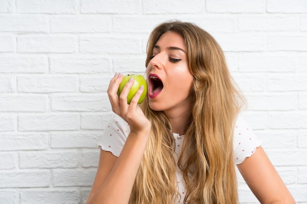 Jeune femme blonde avec une pomme