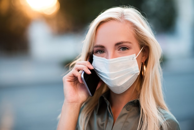 Jeune femme blonde portant un masque de protection médical