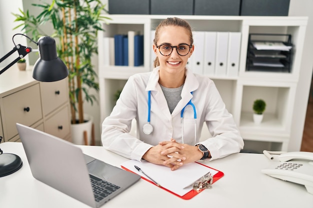 Jeune femme blonde portant un uniforme de médecin travaillant à la clinique