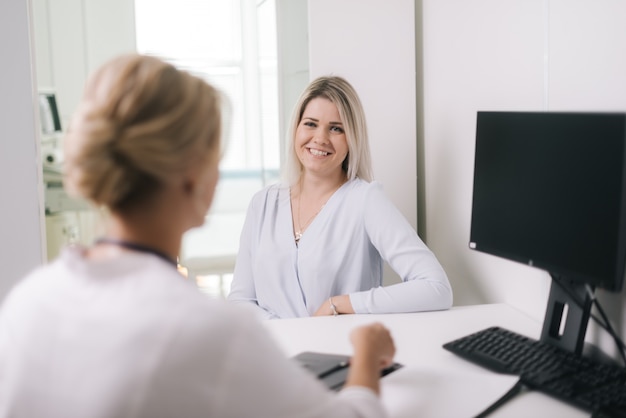 Jeune femme blonde à la réception du médecin en robe de chambre blanche