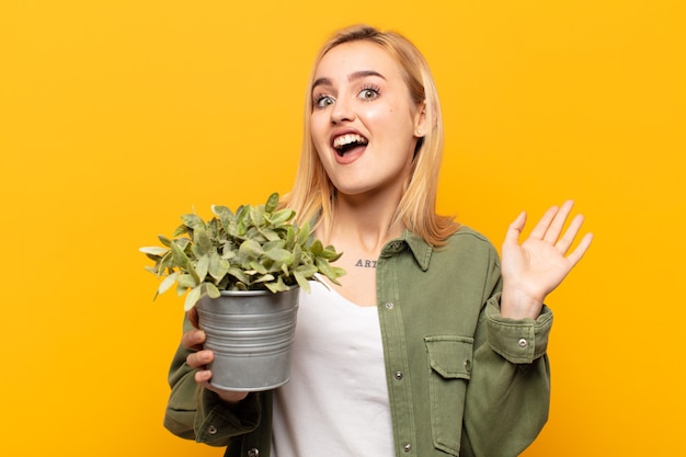 Jeune femme blonde à la recherche heureuse, insouciante, sympathique et détendue, profitant de la vie et du succès, avec une attitude positive