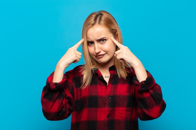 Photo jeune femme blonde avec un regard sérieux et concentré