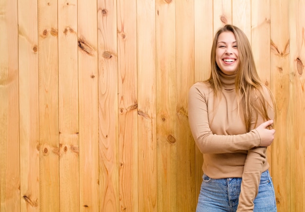 Jeune femme blonde riant timidement et joyeusement, avec une attitude amicale et positive mais peu sûre