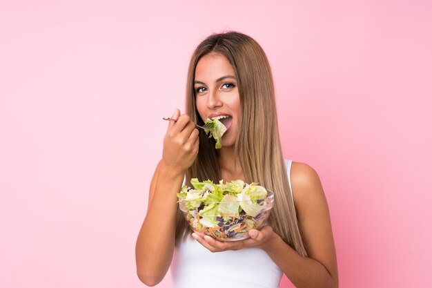 Jeune femme blonde avec une salade isolée