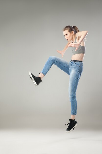 Jeune femme blonde sautant dans les airs tout en regardant loin.Studio shot