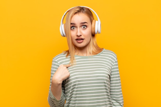 Jeune femme blonde se sentant confuse, perplexe et peu sûre d'elle-même, se demandant qui, moi?