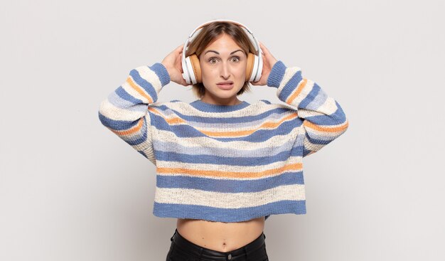 Photo jeune femme blonde se sentant stressée, inquiète, anxieuse ou effrayée, les mains sur la tête, paniquant à l'erreur