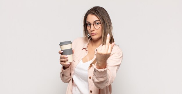 Jeune femme blonde se sentir en colère, ennuyé, rebelle et agressif, retournant le majeur, ripostant