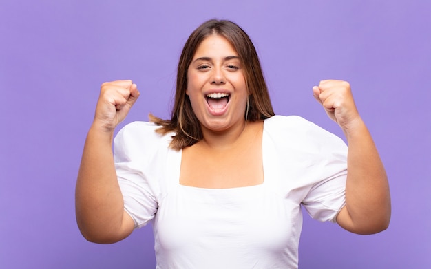 Jeune femme blonde se sentir heureuse, positive et réussie, célébrant la victoire, les réalisations ou la bonne chance