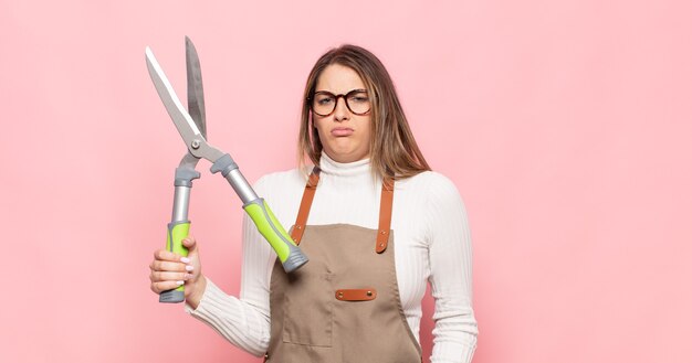 Jeune femme blonde se sentir perplexe et confus, avec une expression stupide et stupéfaite en regardant quelque chose d'inattendu