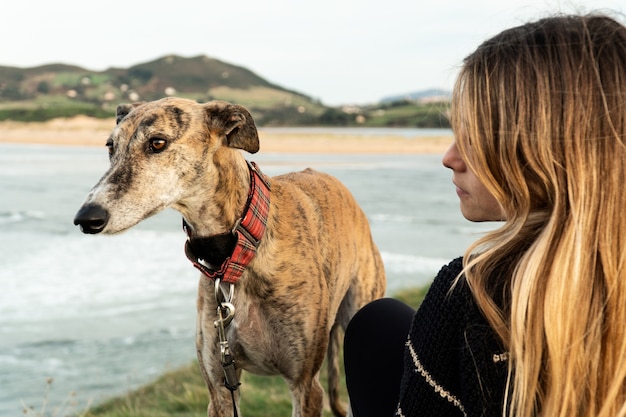 Photo jeune femme blonde et son lévrier sur la rive