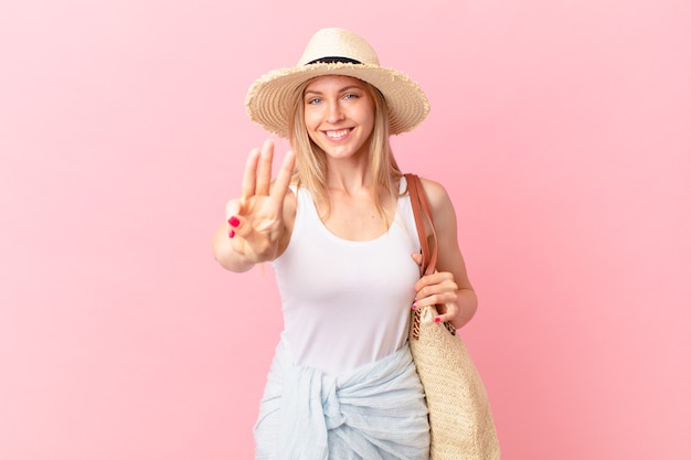 Jeune femme blonde souriante et semblant amicale, montrant le numéro trois