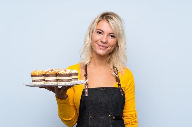 Jeune femme blonde tenant des mini gâteaux