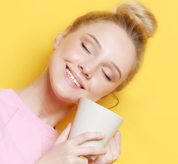 Jeune femme blonde tenant une tasse blanche avec du thé ou du café style de vie et concept alimentaire Gros plan