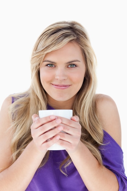 Jeune femme blonde tenant une tasse de café