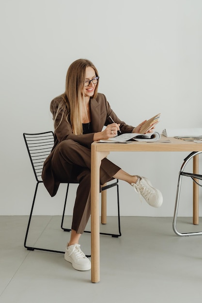 Jeune femme blonde travaillant avec un ordinateur portable et souriant