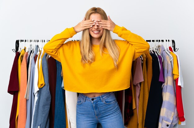 Jeune femme blonde uruguayenne dans un magasin de vêtements couvrant les yeux par les mains