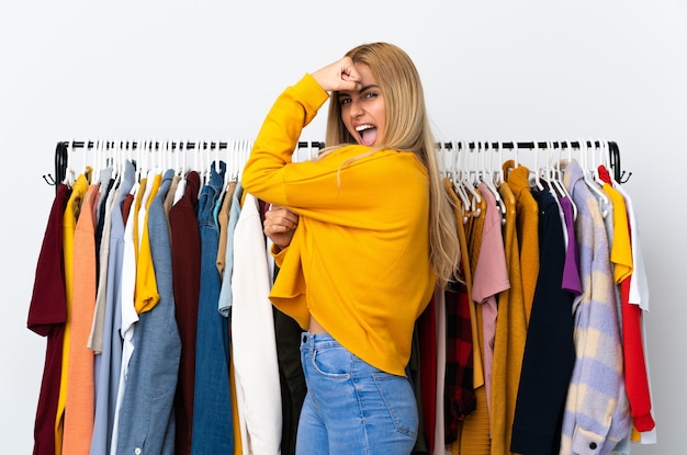 Jeune femme blonde uruguayenne dans un magasin de vêtements faisant un geste fort