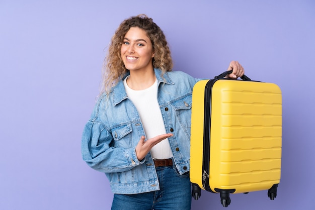 Jeune femme blonde avec valise de voyage