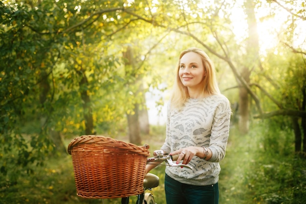 Jeune femme blonde sur un vélo vintage